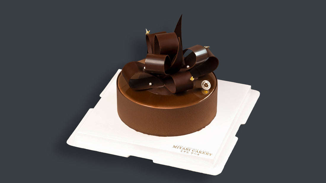 Miyabi Tipsy Whisper chocolate cake with sculpted chocolate curls on a white cake board