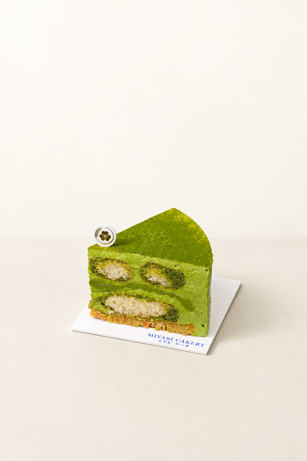 Matcha Tiramisu slice showing matcha mousse, ladyfingers and crumble on an ivory background
